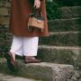woman holding a wicker bag walking up the steps