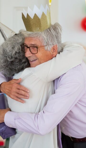 elderly man hugging elderly person